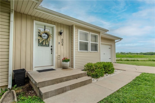 604 Lake Rd, Garden City, MO 64747 - property entrance featuring board and batten siding and a garage
