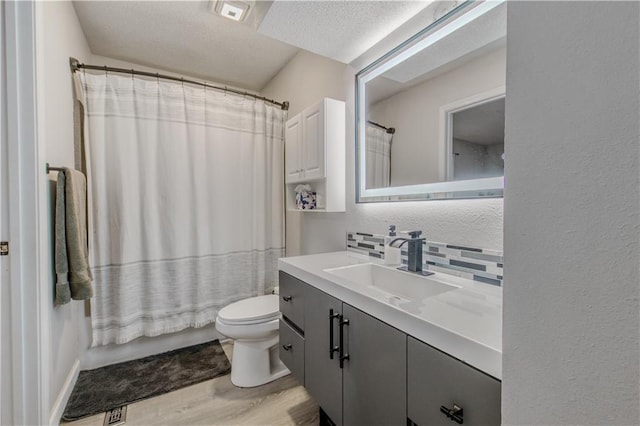 604 Lake Rd, Garden City, MO 64747 - bathroom with vanity, toilet, decorative backsplash, wood finished floors, and a textured ceiling