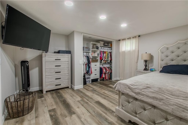 604 Lake Rd, Garden City, MO 64747 - bedroom with wood finished floors, a closet, baseboards, and recessed lighting