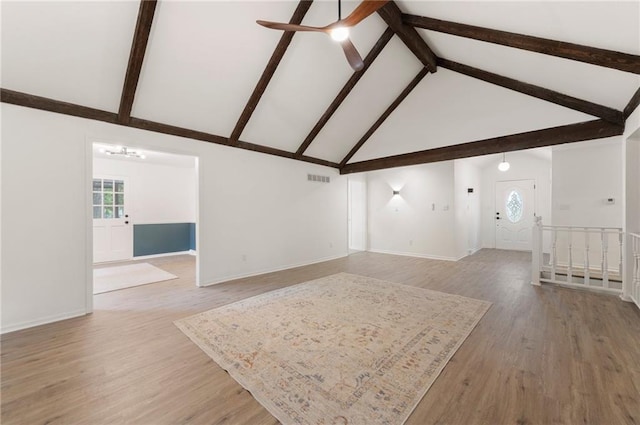 16000 E 28th St S, Independence, MO 64055 - unfurnished living room featuring a ceiling fan, plenty of natural light, beamed ceiling, high vaulted ceiling, and light wood-type flooring