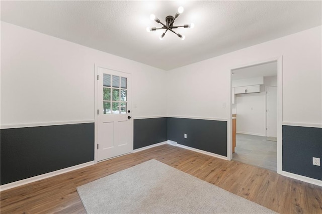 16000 E 28th St S, Independence, MO 64055 - unfurnished room featuring a chandelier, wood finished floors, and baseboards