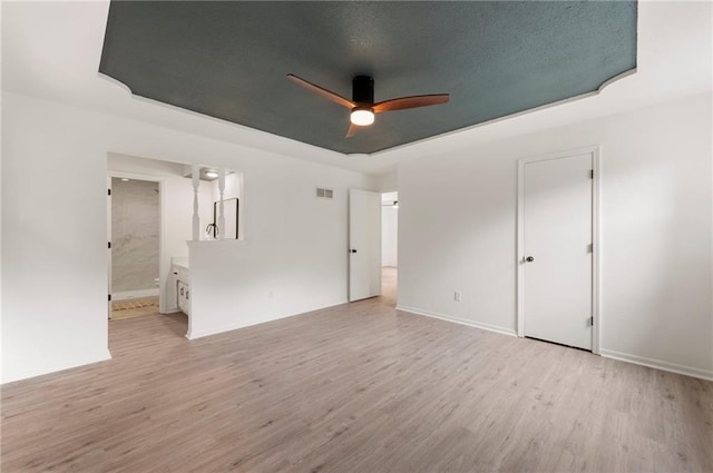 16000 E 28th St S, Independence, MO 64055 - empty room with ceiling fan, light wood-style floors, a tray ceiling, and baseboards