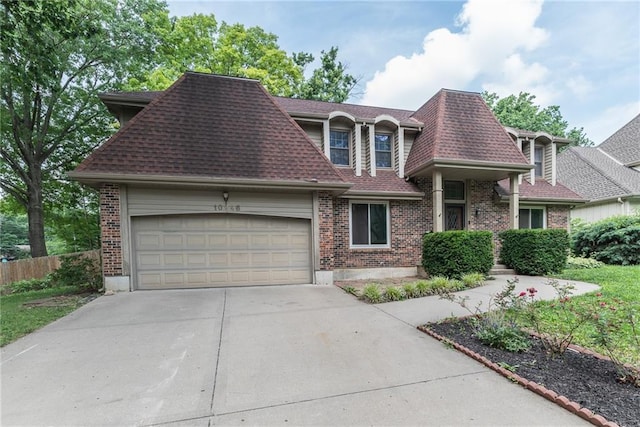 10246 Russell St, Overland Park, KS 66212 - view of front of property featuring a garage, a shingled roof, driveway, and brick siding