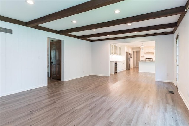 10246 Russell St, Overland Park, KS 66212 - unfurnished living room featuring wood finished floors, beverage cooler, beamed ceiling, and recessed lighting