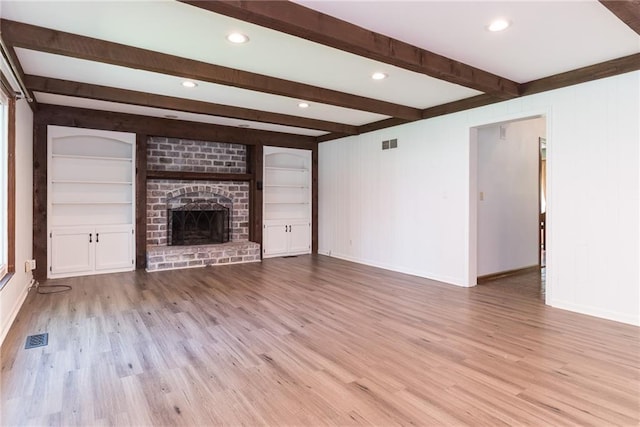 10246 Russell St, Overland Park, KS 66212 - unfurnished living room with wood finished floors, beamed ceiling, a brick fireplace, recessed lighting, and built in shelves