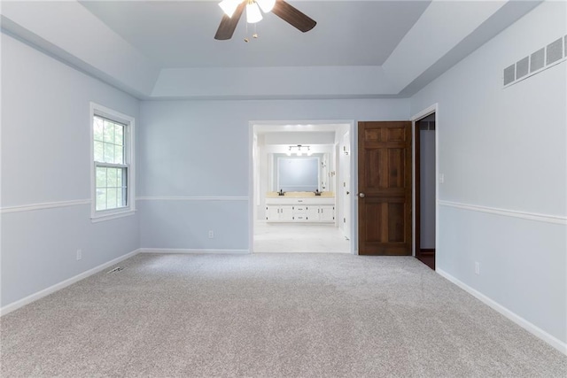 10246 Russell St, Overland Park, KS 66212 - unfurnished bedroom with carpet flooring, a raised ceiling, connected bathroom, and a ceiling fan