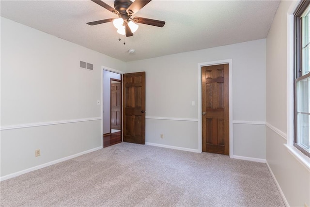 10246 Russell St, Overland Park, KS 66212 - unfurnished bedroom with carpet, multiple windows, a textured ceiling, and ceiling fan