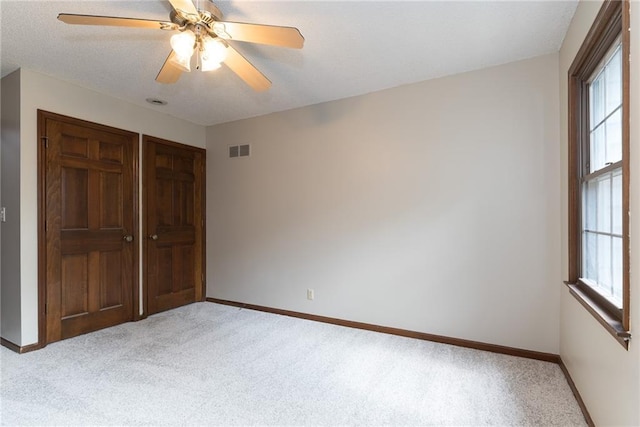 10246 Russell St, Overland Park, KS 66212 - unfurnished bedroom with light carpet, multiple windows, a closet, and a ceiling fan