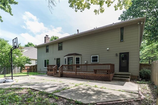 10246 Russell St, Overland Park, KS 66212 - rear view of property featuring a deck, a chimney, and a patio