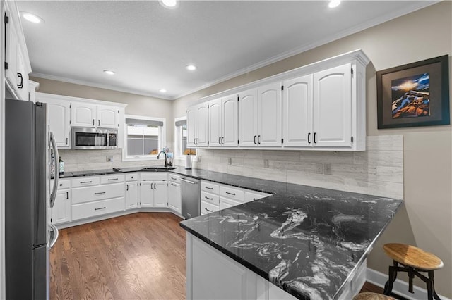 14906 Knorpp Rd, Pleasant Hill, MO 64080 - kitchen with appliances with stainless steel finishes, a peninsula, white cabinets, decorative backsplash, and dark wood-type flooring
