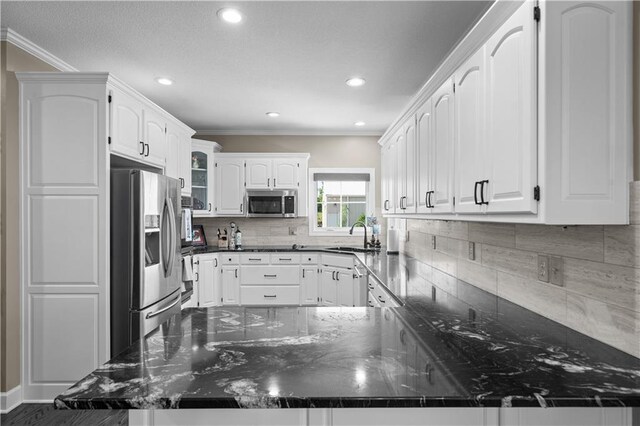 14906 Knorpp Rd, Pleasant Hill, MO 64080 - kitchen with appliances with stainless steel finishes, a peninsula, ornamental molding, white cabinets, and backsplash