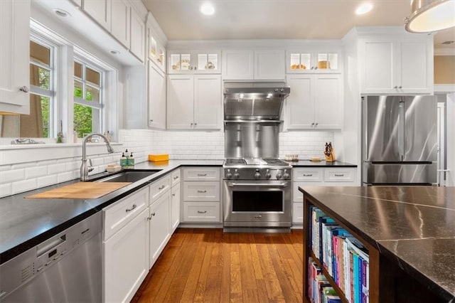 5812 Reinhardt Dr, Fairway, KS 66205 - kitchen featuring appliances with stainless steel finishes, white cabinetry, backsplash, glass insert cabinets, and dark wood-style flooring