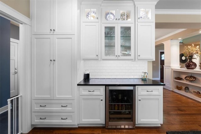 5812 Reinhardt Dr, Fairway, KS 66205 - bar featuring beverage cooler, ornamental molding, tasteful backsplash, dark wood-style flooring, and decorative columns
