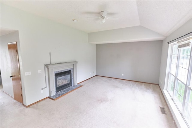 500 Valley View Dr, Frontenac, KS 66763 - unfurnished living room featuring plenty of natural light, ceiling fan, carpet flooring, vaulted ceiling, and a glass covered fireplace