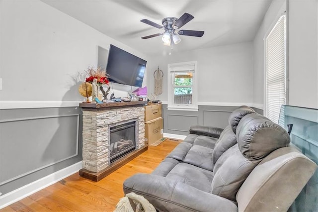 8303 Wabash Ave, Kansas City, MO 64132 - living area with light wood-type flooring, ceiling fan, wainscoting, and a fireplace