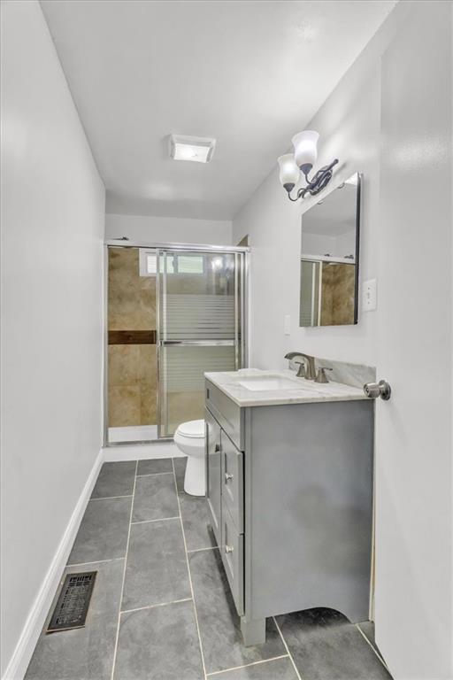 8303 Wabash Ave, Kansas City, MO 64132 - full bath featuring vanity, a shower stall, tile patterned flooring, and a chandelier