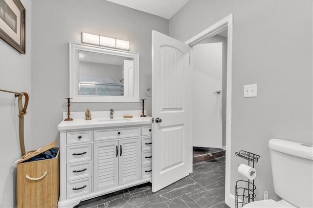8303 Wabash Ave, Kansas City, MO 64132 - bathroom with marble look tiles and vanity