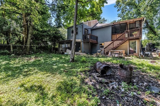 8303 Wabash Ave, Kansas City, MO 64132 - rear view of house with stairway, a wooden deck, and a sunroom