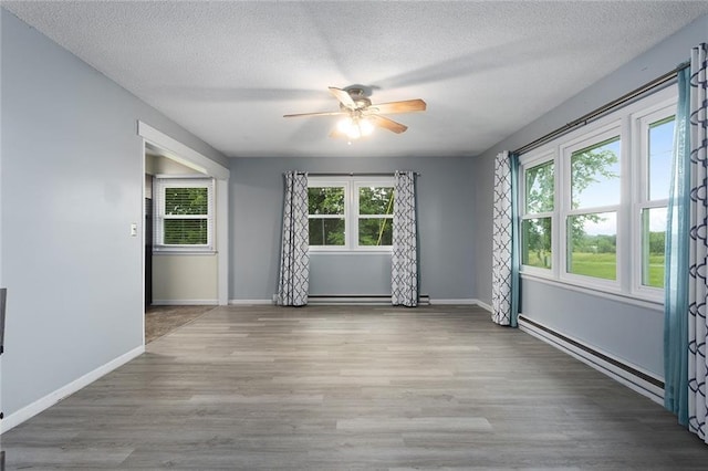 10203 Outer Rd, Odessa, MO 64076 - unfurnished room featuring a ceiling fan, a baseboard radiator, wood finished floors, and a textured ceiling