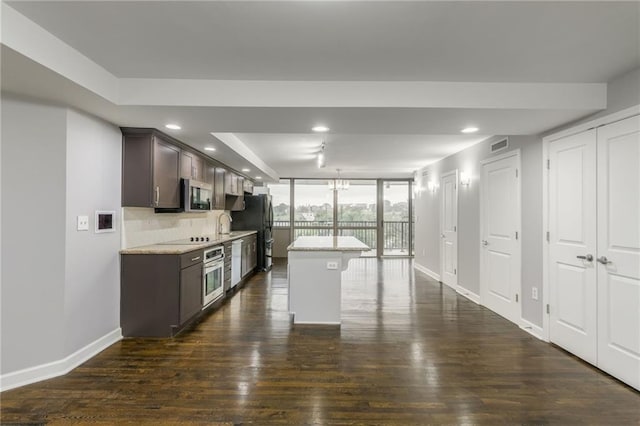 600 E Admiral Blvd Unit 601, Kansas City, MO 64106 - kitchen with stainless steel appliances, a wall of windows, dark brown cabinets, baseboards, and dark wood finished floors
