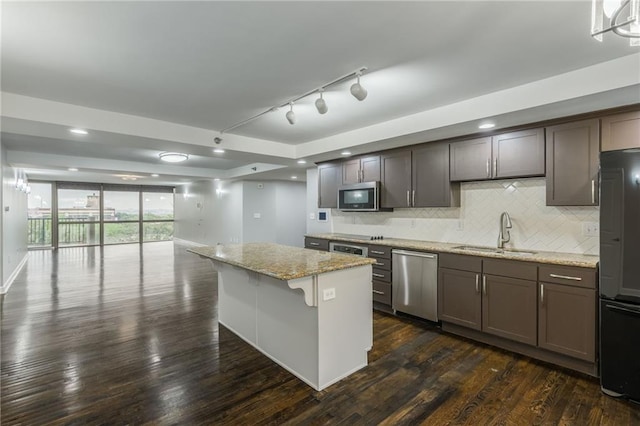 600 E Admiral Blvd Unit 601, Kansas City, MO 64106 - kitchen with stainless steel appliances, a sink, backsplash, light stone countertops, and dark wood-type flooring