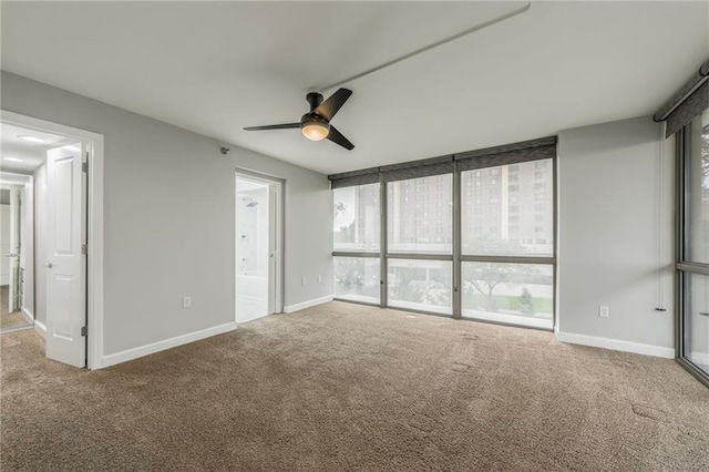 600 E Admiral Blvd Unit 601, Kansas City, MO 64106 - unfurnished bedroom featuring carpet flooring, ensuite bathroom, baseboards, floor to ceiling windows, and ceiling fan