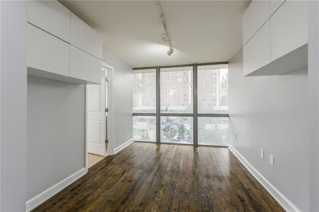 600 E Admiral Blvd Unit 601, Kansas City, MO 64106 - unfurnished dining area featuring expansive windows, track lighting, dark wood-style floors, and baseboards
