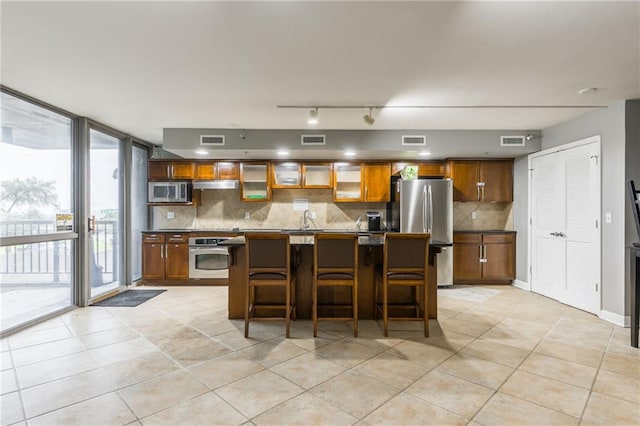 600 E Admiral Blvd Unit 601, Kansas City, MO 64106 - kitchen featuring appliances with stainless steel finishes, tasteful backsplash, light tile patterned flooring, and a center island