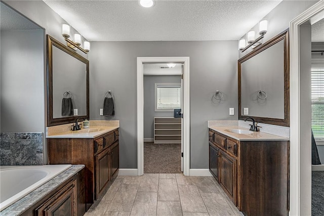 16154 S Canton St, Gardner, KS 66030 - bathroom with two vanities, a textured ceiling, and a garden tub