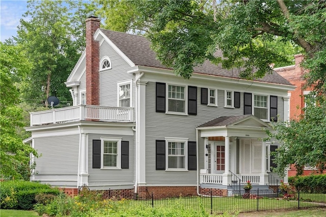 1809 Main St, Lexington, MO 64067 - view of front of property featuring a balcony, a chimney, covered porch, and roof with shingles