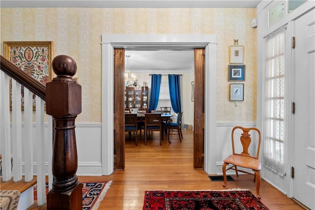 1809 Main St, Lexington, MO 64067 - foyer entrance with wallpapered walls, light wood-type flooring, a wainscoted wall, ornamental molding, and stairs