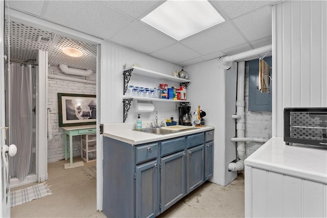 1809 Main St, Lexington, MO 64067 - kitchen featuring concrete floors, blue cabinets, light countertops, a paneled ceiling, and open shelves