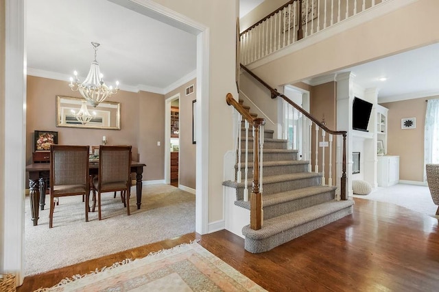 14810 W 72nd St, Shawnee, KS 66216 - stairway with ornamental molding, wood finished floors, and a chandelier
