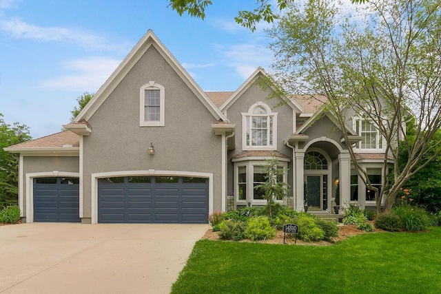 14810 W 72nd St, Shawnee, KS 66216 - view of front facade with stucco siding, driveway, and a front yard