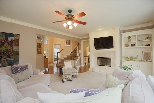 14810 W 72nd St, Shawnee, KS 66216 - living area with a tile fireplace, crown molding, ceiling fan, stairway, and wood finished floors