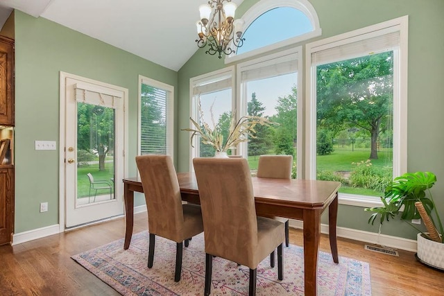 14810 W 72nd St, Shawnee, KS 66216 - dining space with a chandelier, wood finished floors, and vaulted ceiling