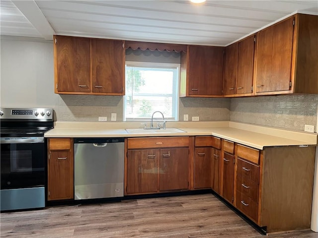 203 N Connor St, Odessa, MO 64076 - kitchen with stainless steel appliances, a sink, light countertops, and light wood-style floors