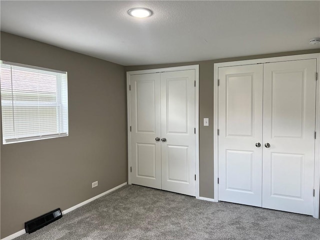 203 N Connor St, Odessa, MO 64076 - unfurnished bedroom featuring two closets, carpet flooring, and baseboards