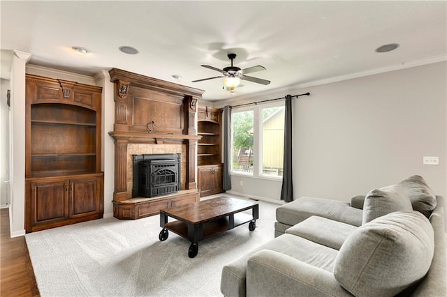 21835 W 175th Ter, Olathe, KS 66062 - living room with a ceiling fan, a fireplace with raised hearth, ornamental molding, and wood finished floors