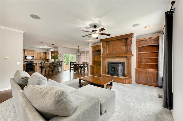 21835 W 175th Ter, Olathe, KS 66062 - living room with ceiling fan, recessed lighting, a fireplace with raised hearth, and crown molding