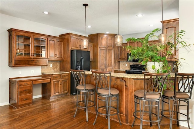21835 W 175th Ter, Olathe, KS 66062 - kitchen with black appliances, dark wood-style flooring, glass insert cabinets, light stone countertops, and a peninsula