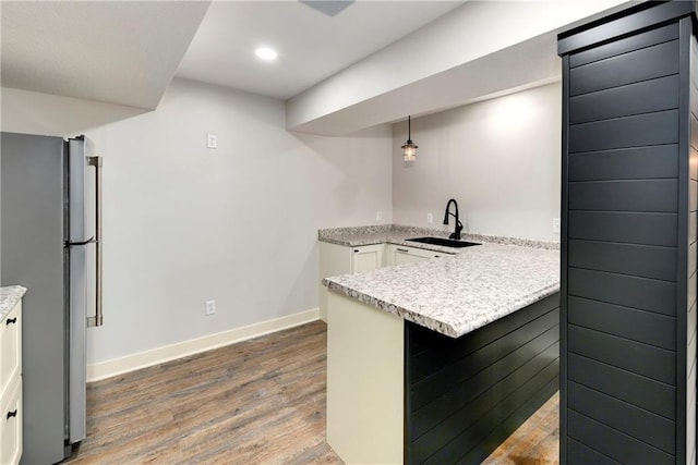 21835 W 175th Ter, Olathe, KS 66062 - kitchen featuring freestanding refrigerator, a peninsula, wood finished floors, light countertops, and white cabinets