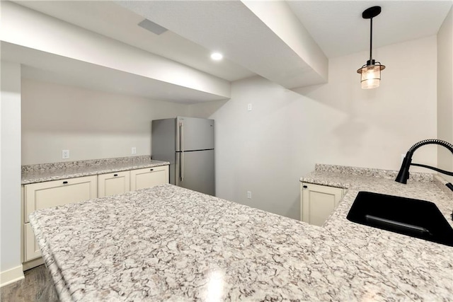 21835 W 175th Ter, Olathe, KS 66062 - kitchen featuring freestanding refrigerator, wood finished floors, a peninsula, and light stone counters