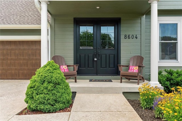 8604 NE 72nd Ter, Kansas City, MO 64158 - view of exterior entry featuring french doors, a porch, and a garage