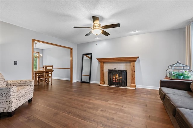 8604 NE 72nd Ter, Kansas City, MO 64158 - living room with wood finished floors, ceiling fan, a tile fireplace, a chandelier, and baseboards