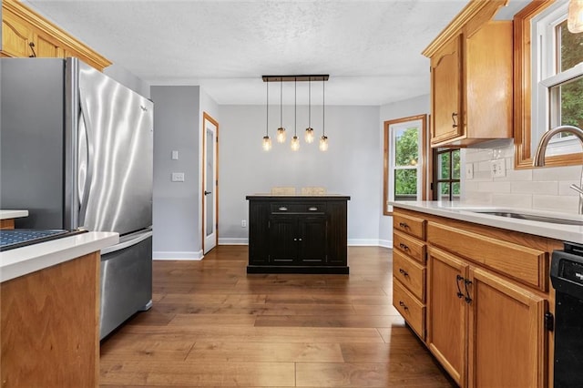 8604 NE 72nd Ter, Kansas City, MO 64158 - kitchen featuring freestanding refrigerator, dishwashing machine, a sink, light countertops, and a textured ceiling