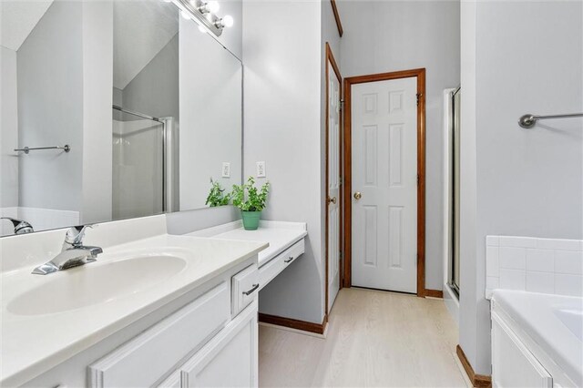 8604 NE 72nd Ter, Kansas City, MO 64158 - bathroom with a stall shower, vanity, wood finished floors, and a garden tub