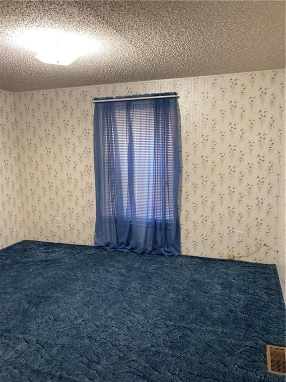 2000 E 19th St Unit 5, Lawrence, KS 66046 - carpeted spare room with wallpapered walls and a textured ceiling