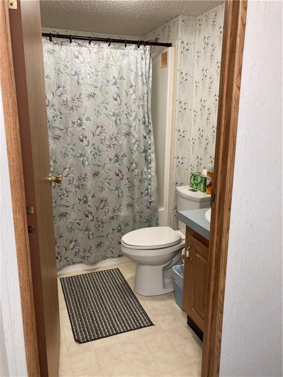 2000 E 19th St Unit 5, Lawrence, KS 66046 - bathroom with vanity, a textured ceiling, wallpapered walls, and shower / bath combo