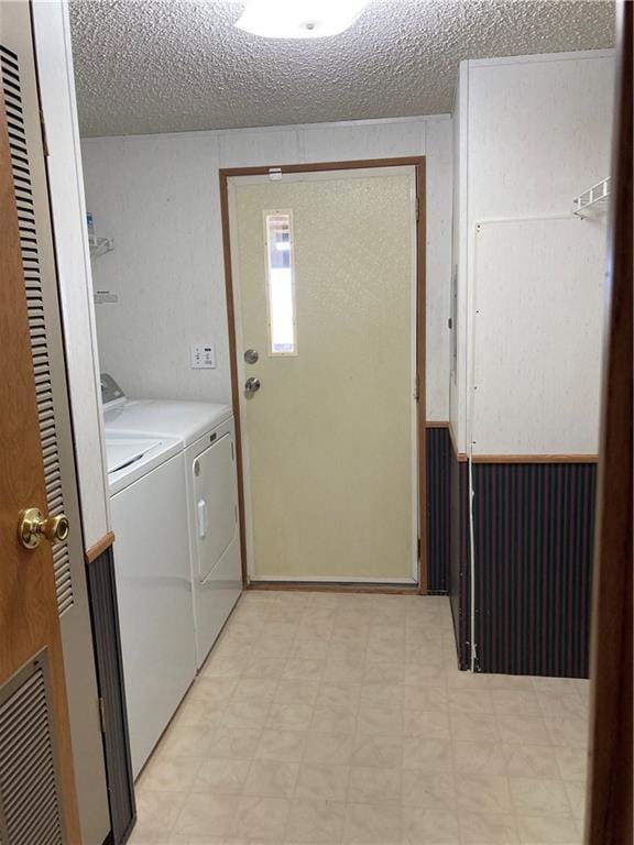 2000 E 19th St Unit 5, Lawrence, KS 66046 - laundry room featuring washing machine and clothes dryer, light floors, and a textured ceiling
